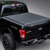 Access Original low-profile soft roll-up tonneau cover on a black Ford F-150 in a dark gray showroom