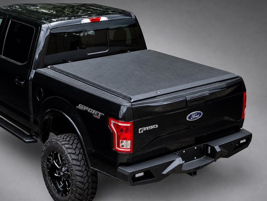 Access Original low-profile soft roll-up tonneau cover on a black Ford F-150 in a dark gray showroom